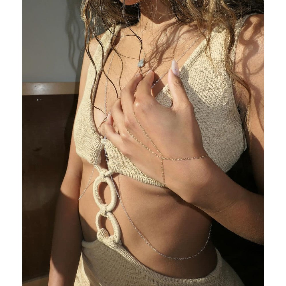 Silver body chain worn with the handchain.