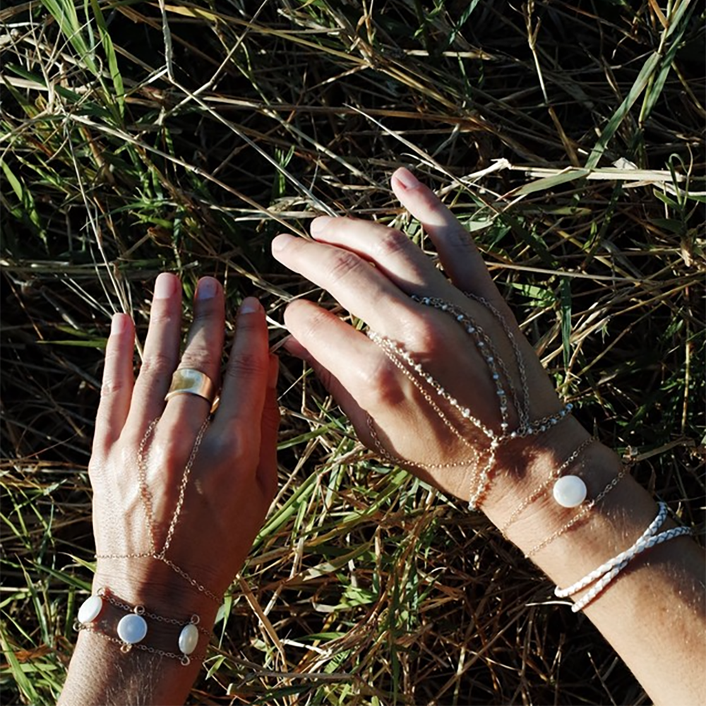 The pearl charm bracelet is made from fresh water pearls and gold fill chain. Worn here with the simple gold handchain bracelet. Find this jewelry on chainsbylauren.us. Adjustable so one size fits all. Chains by Lauren