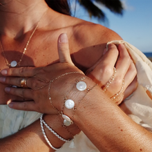 The pearl charm bracelet is made from fresh water pearls and gold fill chain.  Worn here with the simple gold handchain bracelet.  Find this jewelry on chainsbylauren.us.  Adjustable so one size fits all.  Chains by Lauren