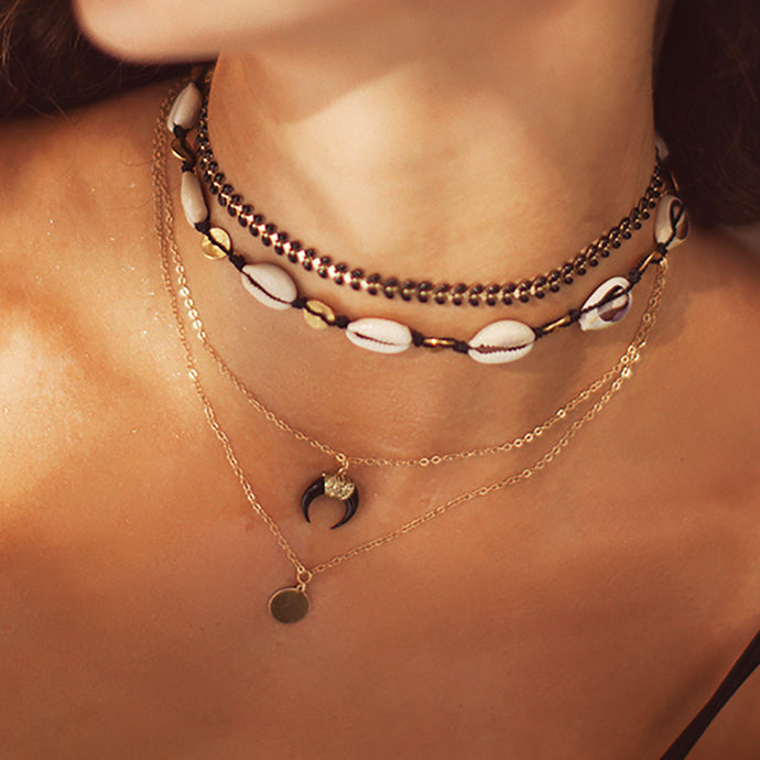Layering necklaces.  The cowrie choker can also be work as a double wrap bracelet.  Chains by Lauren