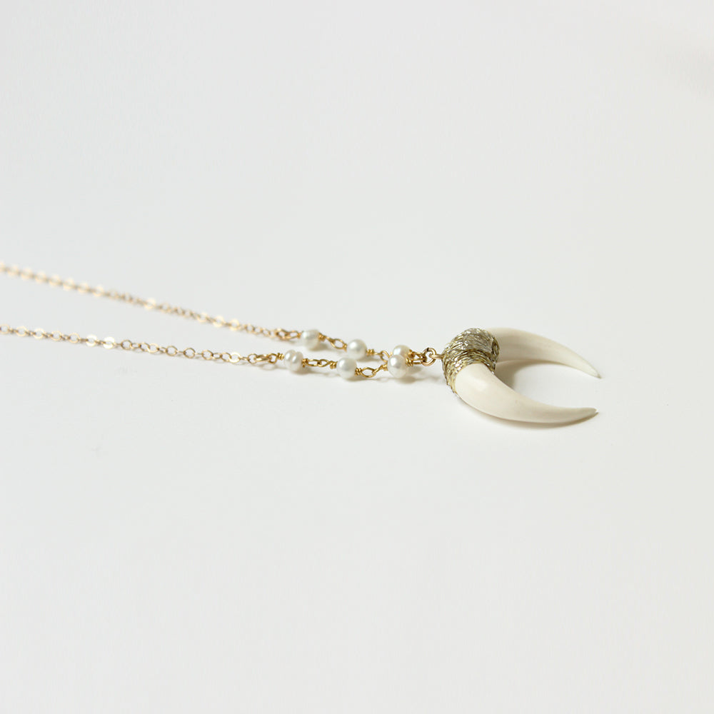 Close up of the white horn necklace in a range of lengths from 18"-24". Made with pearls, and gold fill chain. Adjustable at the back neck. Handmade. Chains by Lauren
